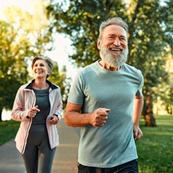 Older couple jogging outside, enjoying good health