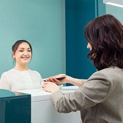 Patient making payment at dental office front desk